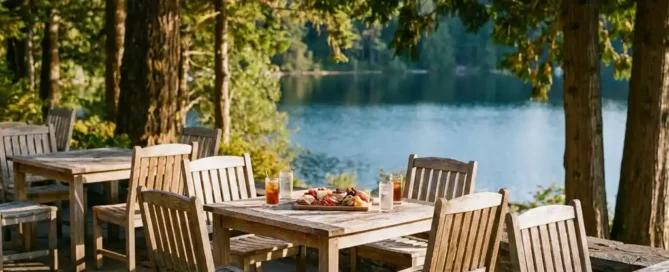 Zonnig houten terras met rustieke tafels, koude drankjes en een charcuterieplank met uitzicht op een bosrijk meer.